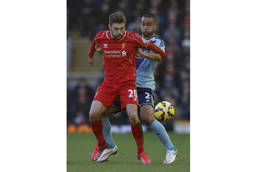 Liverpool's Adam Lallana (L) is challenged by West Ham United's Winston Reid during their English Premier League soccer match at Anfield in Liverpool, northern England January 31, 2015. 