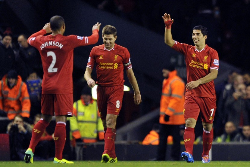 Liverpool's Luis Suarez, right, celebrates after scoring the second goal of the game with teammates Steven Gerrard, center, and Glen Johnson during their English Premier League soccer match against Norwich City at Anfield in Liverpool, England, Wednesday D