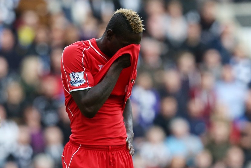 Liverpool's Mario Balotelli covers his face with his shirt during their English Premier League soccer match against Newcastle United at St James' Park, Newcastle, England, Saturday, Nov. 1, 2014. 