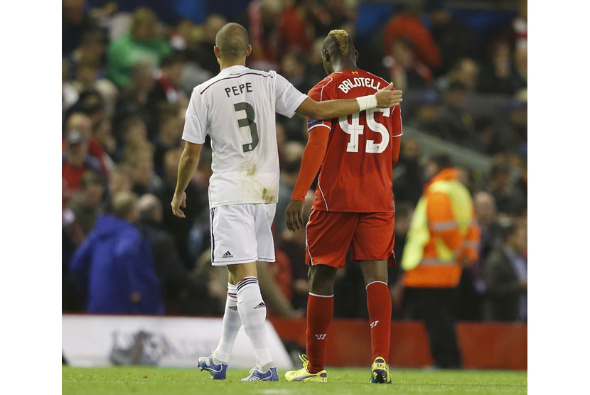 Liverpool's Mario Balotelli (R) walks off the pitch at half-time with Real Madrid's Pepe, before swapping shirts in the tunnel, during their Champions League Group B soccer match at Anfield in Liverpool, northern England October 22, 2014.