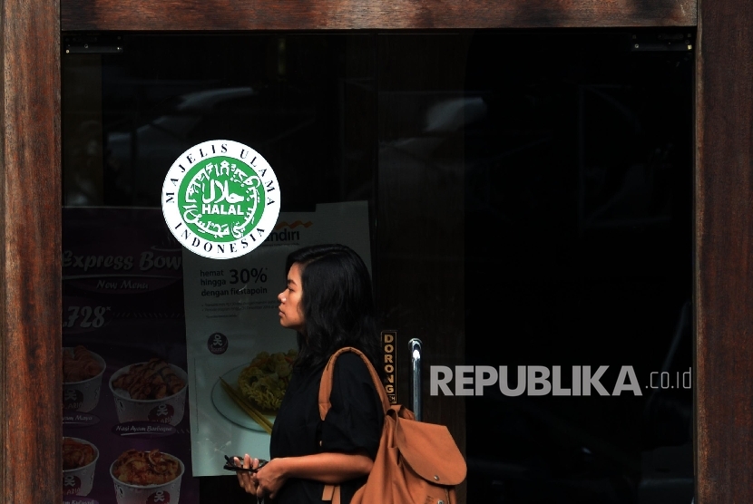 Logo halal Majelis Ulama Indonesia (MUI) terpampang dipintu masuk salah satu restoran cepat saji di Jakarta, Ahad (16/10). 