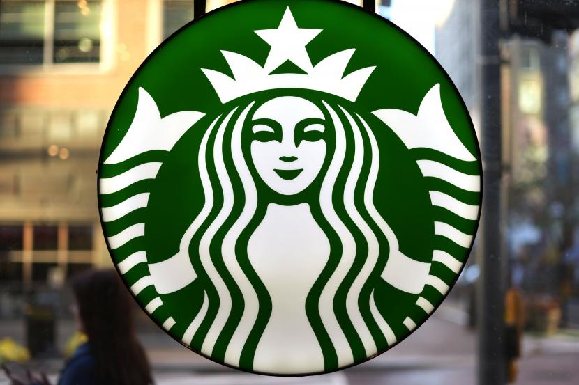 Logo Starbucks dipajang di jendela Starbucks.