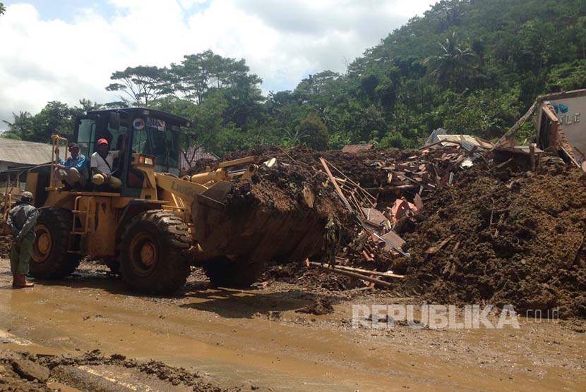  Alat berat berusaha membuka jalan yang tertutup longsor (ilustrasi) 