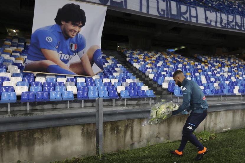  Lorenzo Insigne dari Napoli meletakkan buket bunga di bawah foto Diego Armando Maradona yang diekspos di stadion San Paolo, Minggu, 29 November 2020, sebelum pertandingan sepak bola Serie A Italia antara Napoli dan Roma, di Naples, Italia.