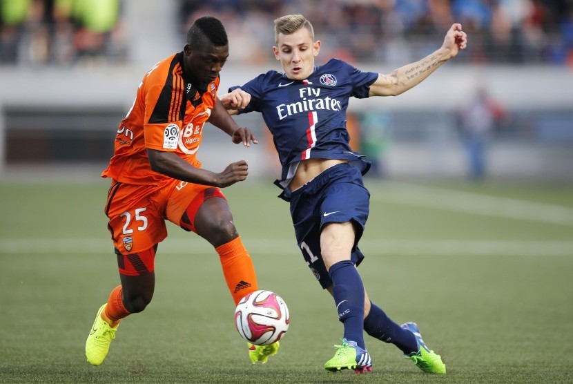 Lorient's Lamine Gassama (L) fights for the ball with Paris St Germain's Lucas Digne during their French Ligue 1 soccer match at the Moustoir stadium in Lorient November 1, 2014