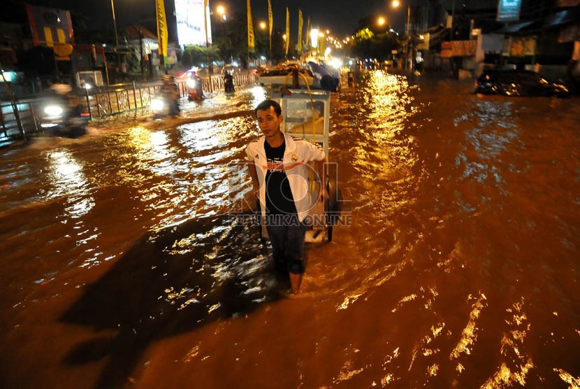 Luapan air Kali Ciliwung merendam Jalan KH Abdullah Syafe'i, Kampung Melayu Besar, Jakarta, Ahad (12/1) malam.  (Republika/Prayogi)