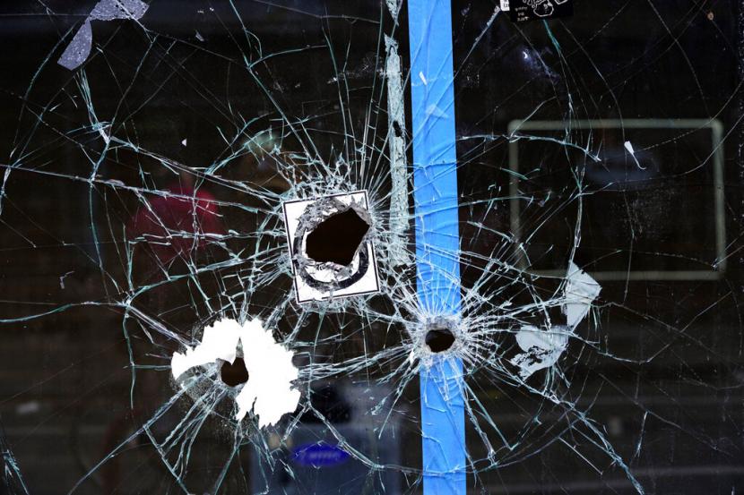 Lubang peluru masih ada di jendela etalase di lokasi penembakan massal di South Street di Philadelphia, Ahad, 5 Juni 2022.