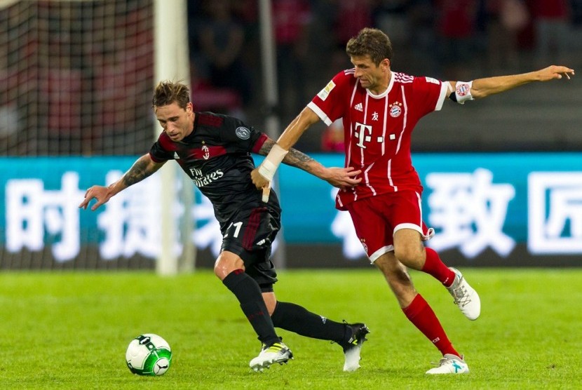 Lucas Biglia (kiri) membela AC Milan melawan Bayern Muenchen pada laga International Champions Cup.