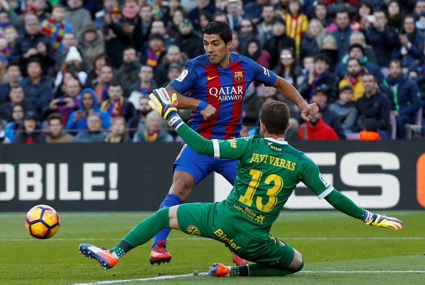 Luis Suarez saat menaklukkan kiper Las Palmas Javi Varas.