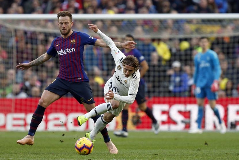Luka Modric berduel dengan rekan senegaranya Ivan Rakiticpada laga Liga Spanyol antara Barcelona FC melawan Real Madrid di Camp Nou, Barcelona, Ahad (28/10).