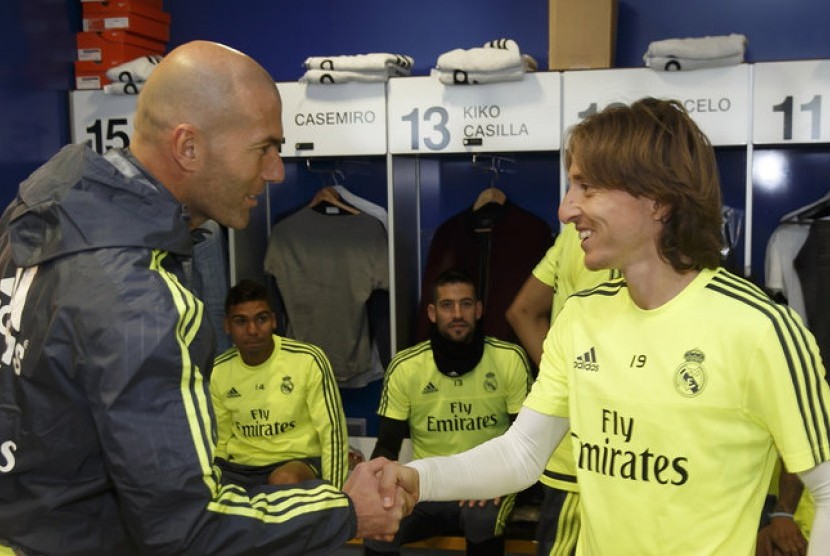 Luka Modric berjabat tangan dengan pelatih Zinedine Zidane.