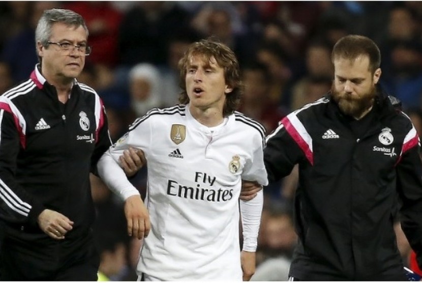 Luka Modric (tengah) saat dipapah keluar lapangan akibat cedera.