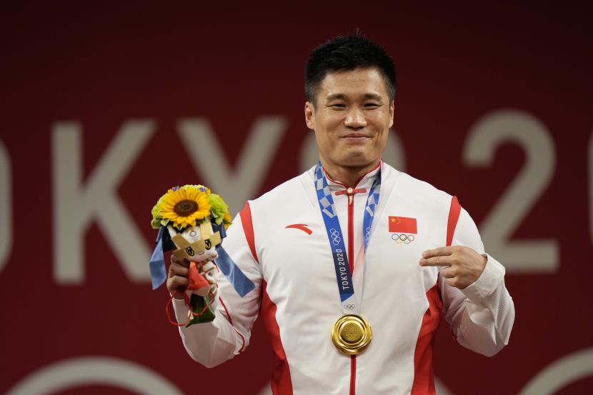 Lyu Xiaojun dari China merayakan di podium setelah memenangkan medali emas di cabang angkat besi 81kg putra, di Olimpiade Musim Panas 2020, Sabtu, 31 Juli 2021, di Tokyo, Jepang.