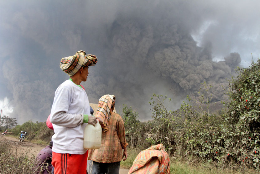 Warga menyaksikan erupsi Gunung Sinabung di Kabupaten Karo, Sumatera Utara, Sabtu (1/2).  (AP Photo)