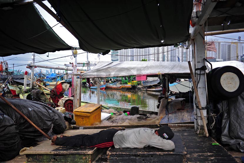   Nelayan beristirahat diatas kapalnya yang bersandar di Pelabuhan Muara Angke, Jakarta, Ahad (2/1).   (Republika/Adhi Wicaksono)