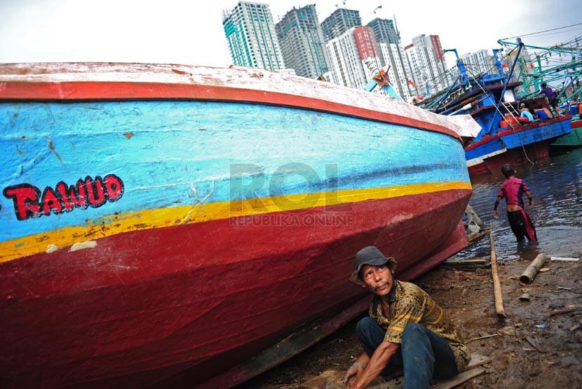  Nelayan memperbaiki kapalnya yang bersandar di Pelabuhan Muara Angke, Jakarta, Ahad (2/1).  (Republika/Adhi Wicaksono)