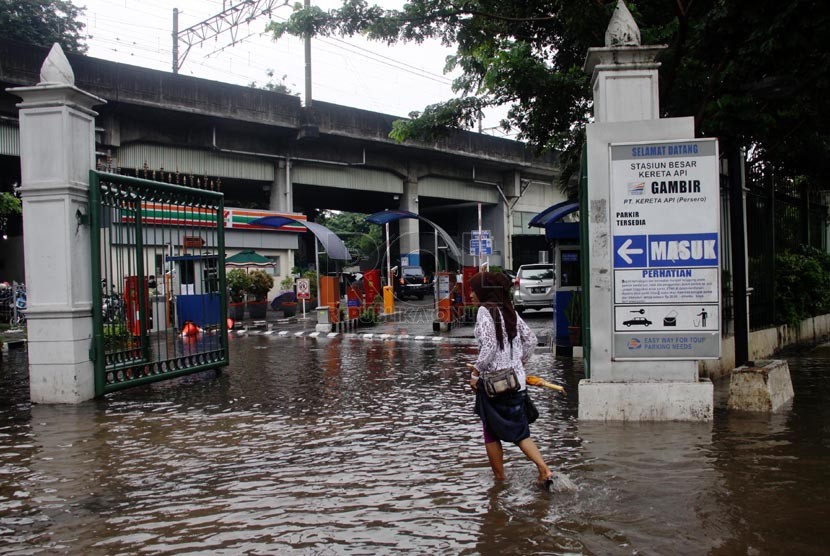  Warga melewati genangan air akibat air di Jalan Medan Merdeka Timur, Jakarta Pusat, Rabu (5/2). (Republika/Yasin Habibi)