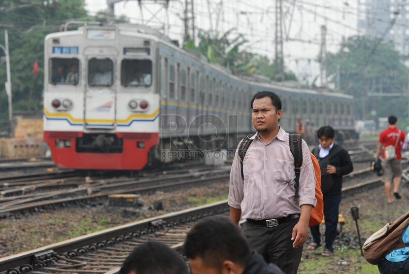  Penumpang KRL berjalan kaki melintasi rel saat terjadi gangguan operasional KRL yang hanya beroperasi hingga Stasiun Manggarai, Jakarta Selatan, Rabu (5/2). (Republika/Rakhmawaty La'lang)