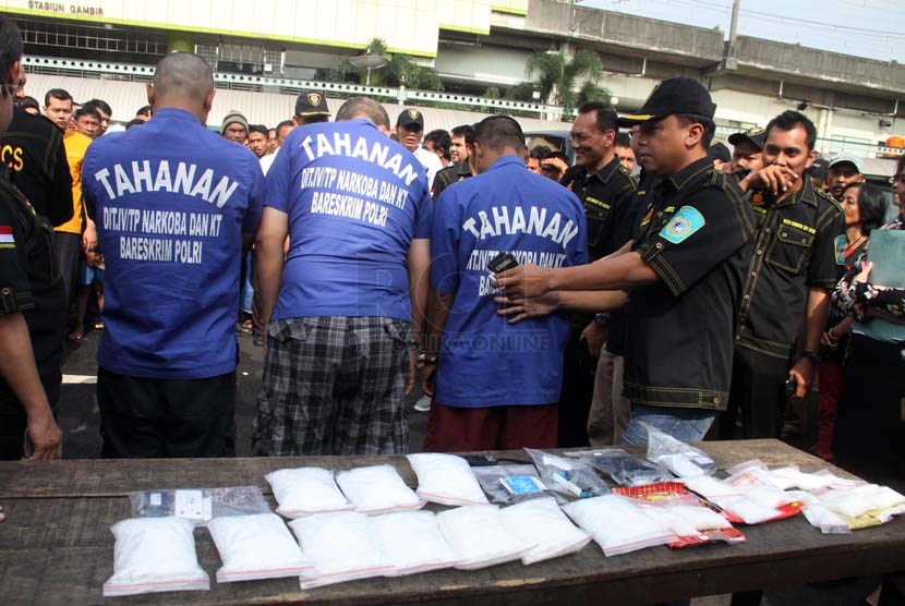  Direktorat Tindak Pidana Narkoba Bareskrim Polri menunjukkan tiga orang tersangka beserta barang bukti berupa narkotika jenis sabu ketika konferensi pers di Stasiun Kereta Api Gambir, Jakarta, Senin (10/2).  (Republika/Yasin Habibi)