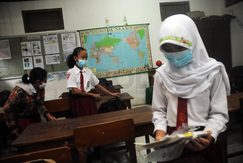  Siswa SDN Banjaran VI Kediri, Jawa Timur, Senin (17/2), dengan menggunakan masker mulai kembali bersekolah.    (Republika/Adhi Wicaksono)