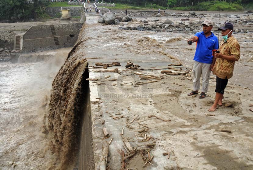 Warga menyaksikan aliran lahar dingin di tanggul Waduk Siman, Kabupaten Kediri, Jawa Timur, Rabu (19/2).  (Republika/Adhi Wicaksono)