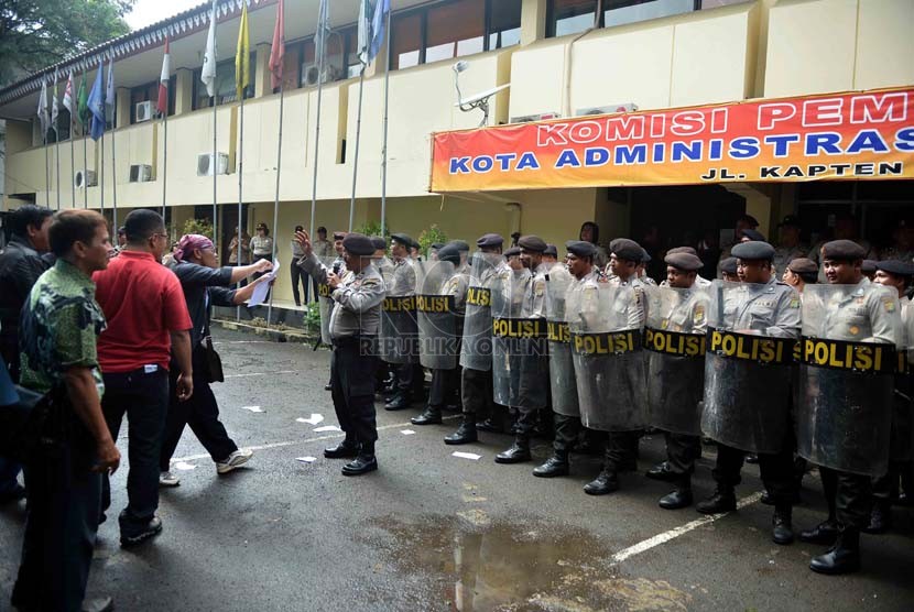  Petugas kepolisian menghalau para demonstran yang memaksa masuk ke kantor KPU saat simulasi pemilu di depan kantor KPU Jakarta Selatan, Jumat (21/2). (Republika/Agung Supriyanto)
