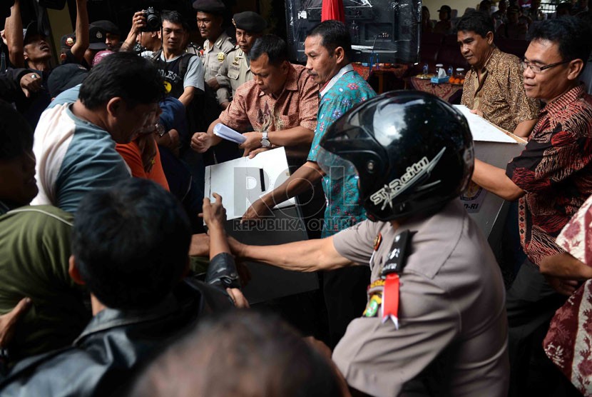  Petugas kepolisian mengamankan kotak suara dari amukan demontran saat simulasi pemilu di depan kantor KPU Jakarta Selatan, Jumat (21/2).  (Republika/Agung Supriyanto)