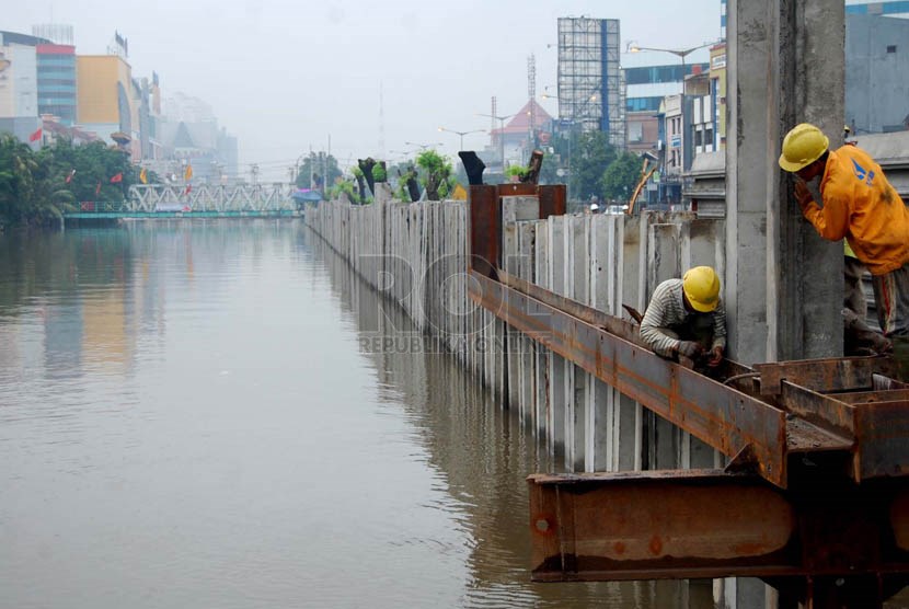 Pekerja memasang beton di proyek pembangunan drainase Sungai Ciliwung, Jalan Gunung Sahari Raya, Jakarta Pusat, Rabu (26/2).  (foto: Raisan Al Farisi)