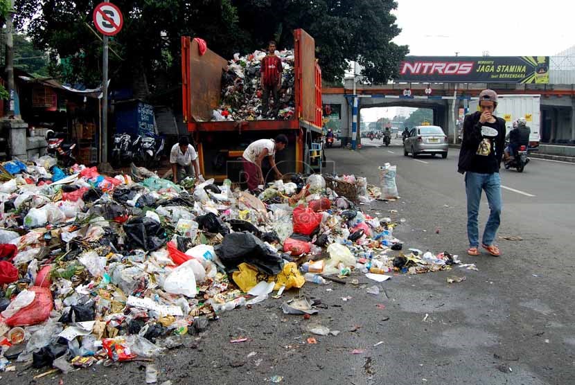 Seorang pengguna jalan melintasi sampah yang berserakan di bahu Jalan Matraman Raya, Jakarta Timur, Rabu (26/2).    (foto: Raisan Al Farisi)