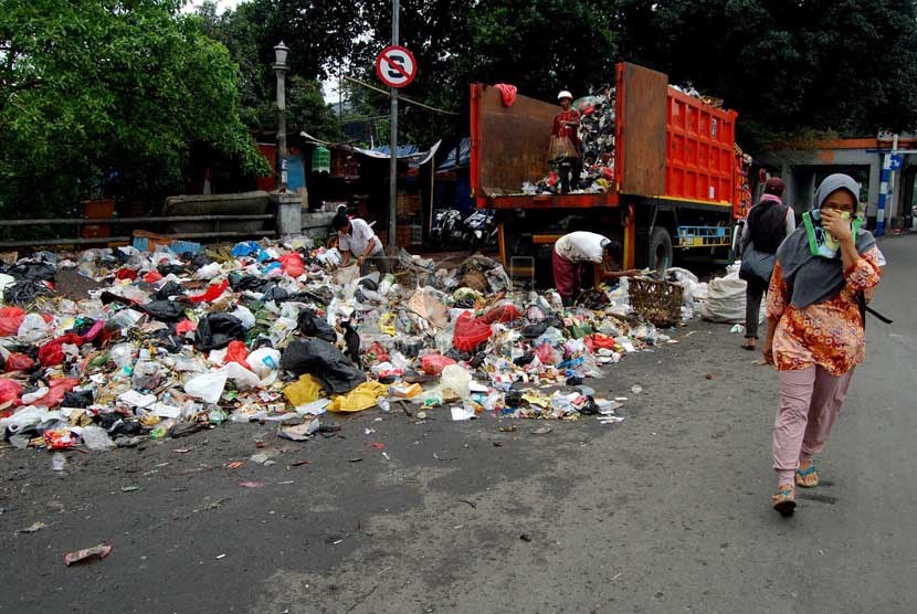 Seorang pengguna jalan melintasi sampah yang berserakan di bahu Jalan Matraman Raya, Jakarta Timur, Rabu (26/2).   (foto: Raisan Al Farisi)