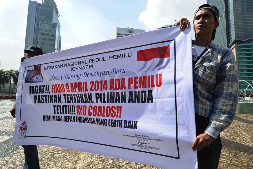    Relawan dari Gerakan Nasional Peduli Pemilu (Genapp) merentangkan spanduk sosialisasi Pemilu 2014 di Bundaran HI, Jakarta, Selasa (4/3). (Republika/Tahta Aidilla)