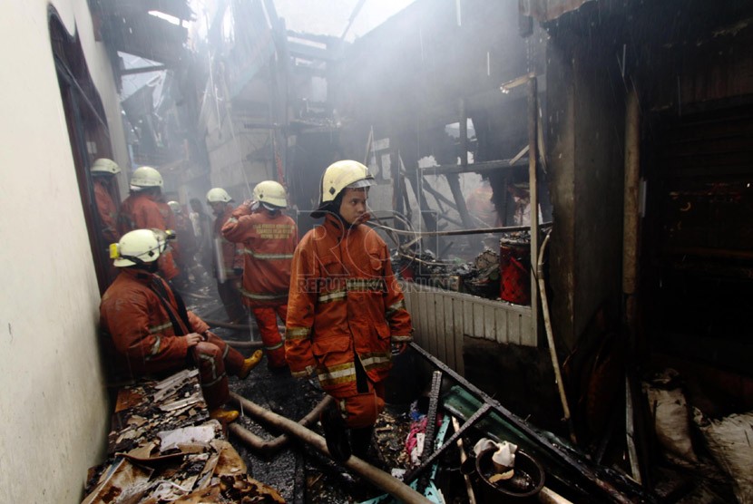  Petugas pemadam kebakaran memadamkan api saat kebakaran melanda permukiman padat di kawasan Jembatan Besi, Tambora, Jakarta Barat, Jumat (7/3).  (Republika/Yasin Habibi)