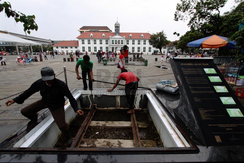   Pekerja membongkar tutup Monumen Jalur Trem yang ada di kawasan Kota Tua, Jakarta Barat, Senin (10/3).   (Republika/Yasin Habibi)