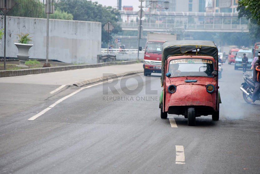  Sebuah angkutan bemo melintas di kawasan Grogol, Jakarta Barat, Senin (10/3).   (foto : Raisan Al Farisi)