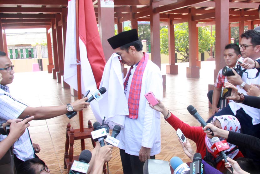 Gubernur DKI Jakarta Joko Widodo mencium bendera Merah Putih seusai diumumkan sebagai  Capres PDIP, di Rumah Pitung, Marunda, Jakarta Utara (14/3). (Antara/Heru)