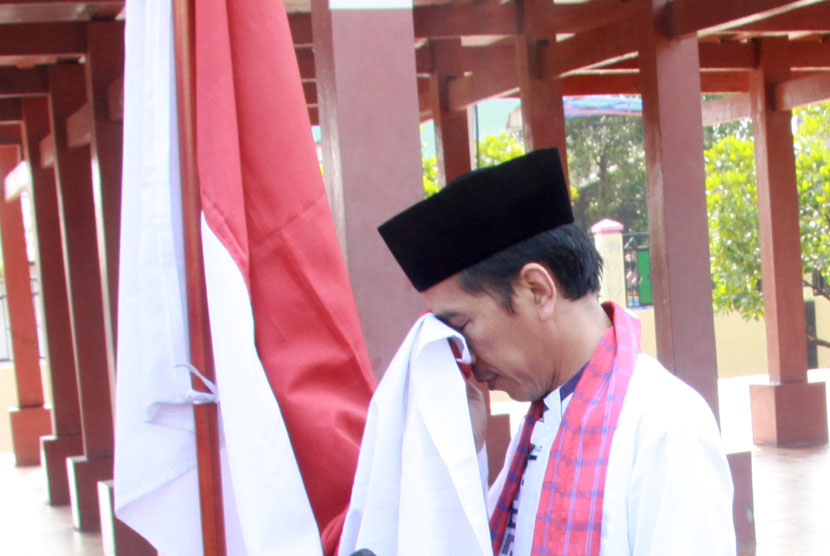 Gubernur DKI Jakarta Joko Widodo mencium bendera Merah Putih seusai diumumkan sebagai  Capres PDIP, di Rumah Pitung, Marunda, Jakarta Utara (14/3). (Antara/Heru)