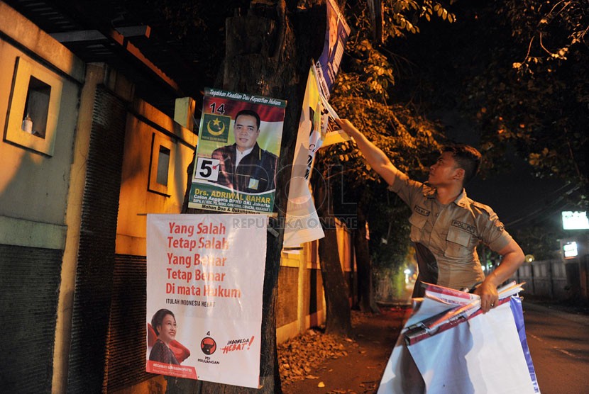 Petugas Kamtibmas Bambu Apus melakukan penertiban atribut kampanye yang dipasang di sembarang tempat di kawasan Bambu Apus, Jakarta Timur, Sabtu (22/3).  (Republika/Edwin Dwi Putranto)