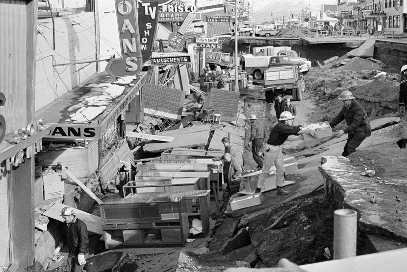 Dalam foto yang diambil pada 30 Maret 1964 lalu, warga membersihkan reruntuhan akibat gempa bumi di Alaska. (AP)