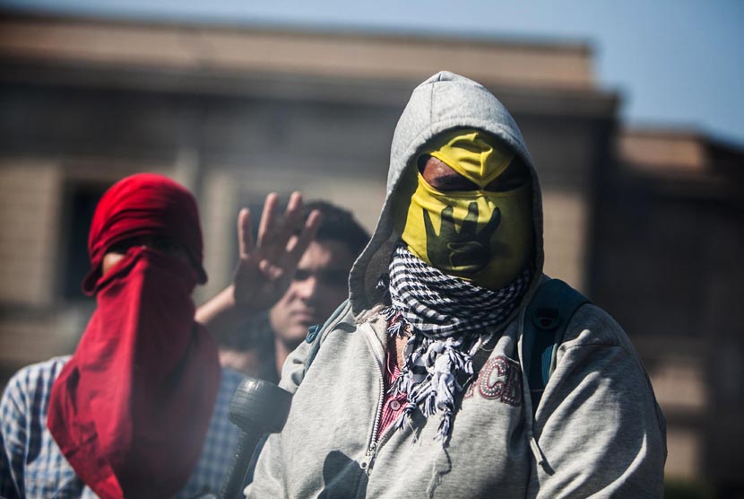   Aksi unjuk rasa pendukung Presiden terguling Muhammad Mursi yang berujung bentrok dengan pasukan keamanan di Universitas Kairo, Giza, Mesir, Rabu (26/3).  (AP/Amru Taha)