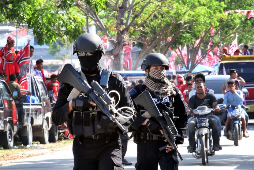   Dua personel polisi dari unit Gegana bersenjata lengkap menjaga kawasan kampanye Partai Aceh (PA) di lapangan Rancong, Muara Satu, Lhokseumawe, Aceh, Rabu (2/4).  (Antara/Rahmad)