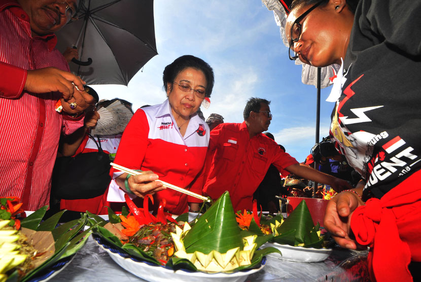 Ketua Umum PDI Perjuangan Megawati Soekarno Putri (tengah) mencicipi makanan saat lomba masakan tradisional Bali di Lapangan Busungliu, Buleleng, Bali, Kamis (3/4). (Antara/Zabur Karuru)