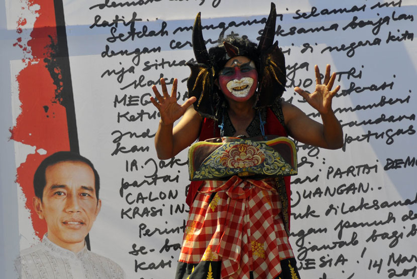  Seorang simpatisan berkostum banteng bergoyang saat mengikuti kampanye PDI Perjuangan di lapangan Busungliu, Buleleng, Bali, Kamis (3/4). (Antara/Zabur Karuru)