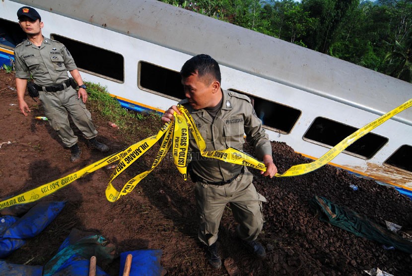  Petugas memasang garis polisi di lokasi terperosoknya kereta api Malabar jurusan Bandung - Malang yang di Kampung  Cikerung,  Desa Mekarsari, Kecamatan Kadipaten, Tasikmalaya, Sabtu (5/4). (foto: Septianjar Muharam)