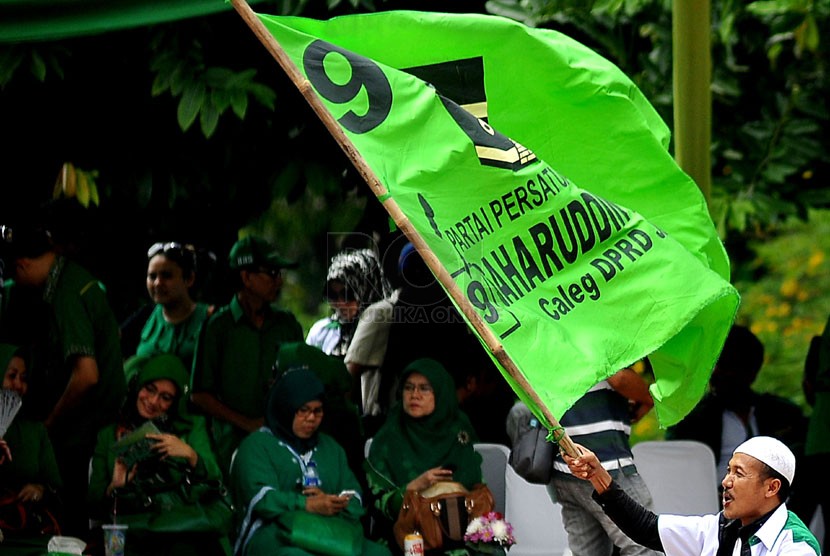 Simpatisan mengibarkan bendera Partai Persatuan Pembangunan (PPP) saat kampanye PPP Tugu Proklamasi, Jakarta Pusat, Sabtu (5/4). (Republika/Prayogi)