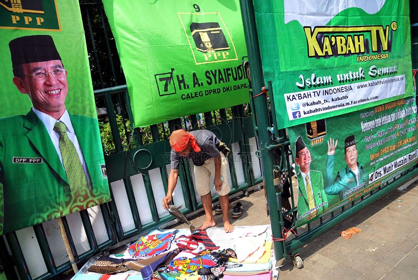  Seorang pedagang mengelar dagangannya saat berlangsung kampanye Partai Persatuan Pembangunan (PPP) di Tugu Proklamasi, Jakarta Pusat, Sabtu (5/4). (Republika/Prayogi)