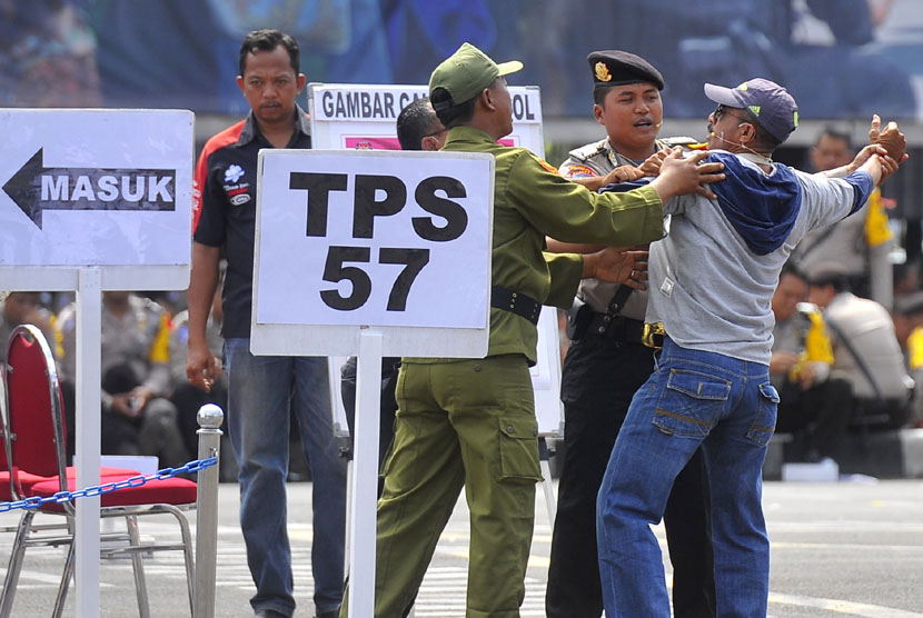 Petugas kepolisian serta linmas berusaha menenangkan warga yang tidak dapat menggunakan hak suaranya ketika simulasi pengamanan tempat pemungutan suara (TPS) di Mapolda Metro Jaya Jakarta, Senin (7/4).  (Antara/Wahyu Putro)