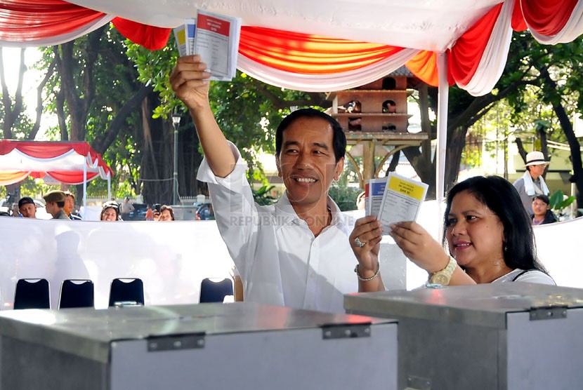 Gubernur DKI Jakarta, Joko Widodo, yang juga bakal capres dari PDIP (kiri) bersama istrinya Iriana mencoblos di TPS 27 Menteng, Jakarta Pusat, Rabu (9/4). (Republika/Prayogi)