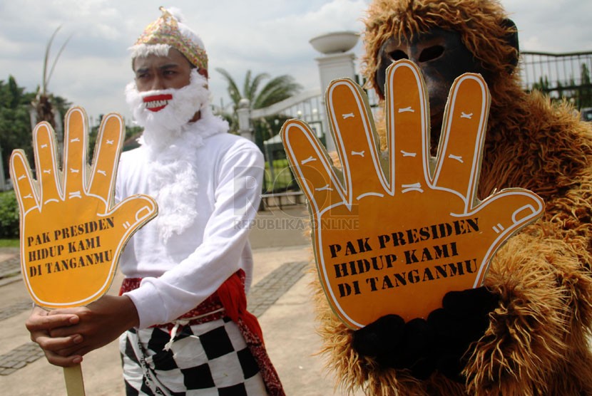   Aktivis orangutan dari Center for Orangutan Protection menggelar aksi dengan mengenakan kostum orangutan dan tokoh wayang Hanoman di depan Istana Merdeka, Jakarta, Rabu (16/4). (Republika/Yasin Habibi)