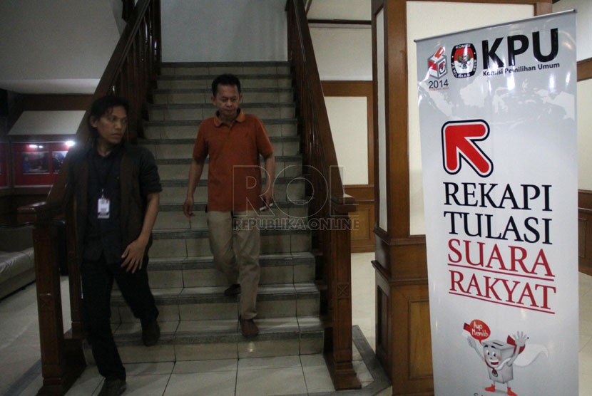   Peserta rapat melintas di depan ruang Rapat Pleno Terbuka Rekapitulasi Nasional Penghitungan Suara Pemilu DPR & DPD tahun 2014 di ruang sidang utama KPU, Jakarta, Ahad (27/4). (Republika/Yasin Habibi)