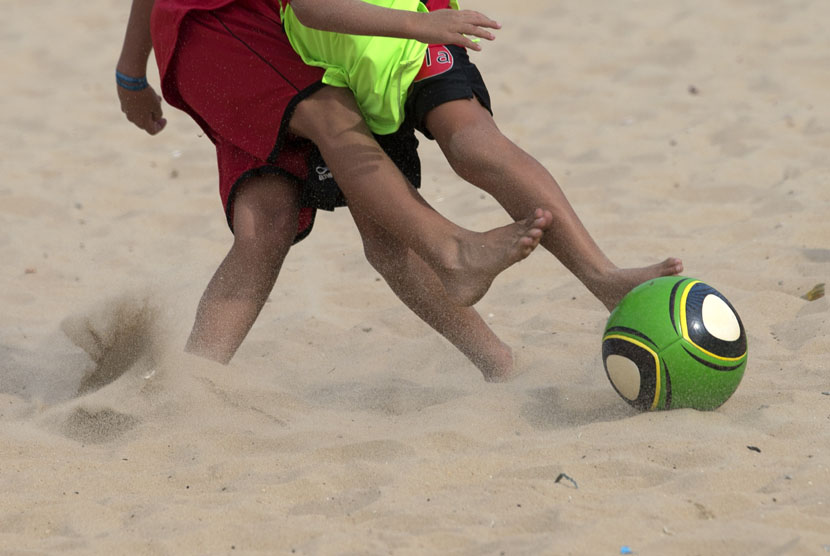    Dua anak laki-laki berebut bola saat mereka berlatih sepak bola di  pantai Ipanema, Rio de Janeiro, Brasil, Rabu (7/5). (AP/Hassan Ammar)